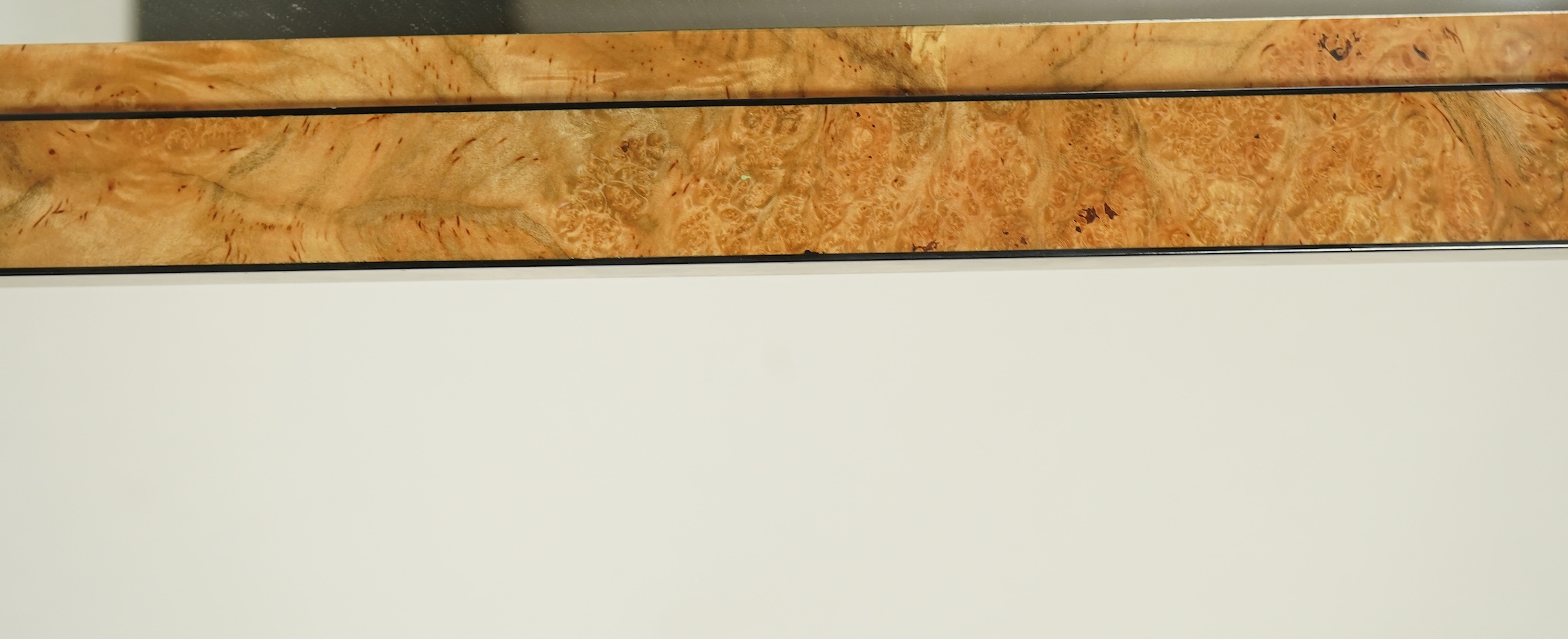 An Art Deco style sweetgum veneered rectangular overmantel mirror